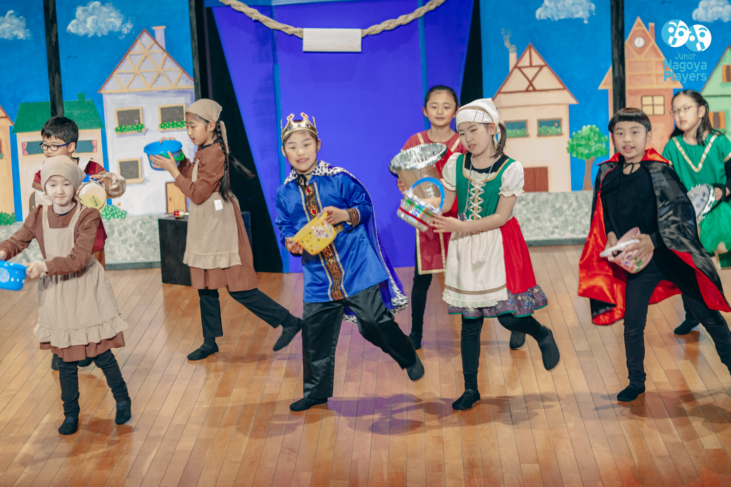 Young performers from Emma Amazing and the Bucket Fillers holding colourful buckets on stage
